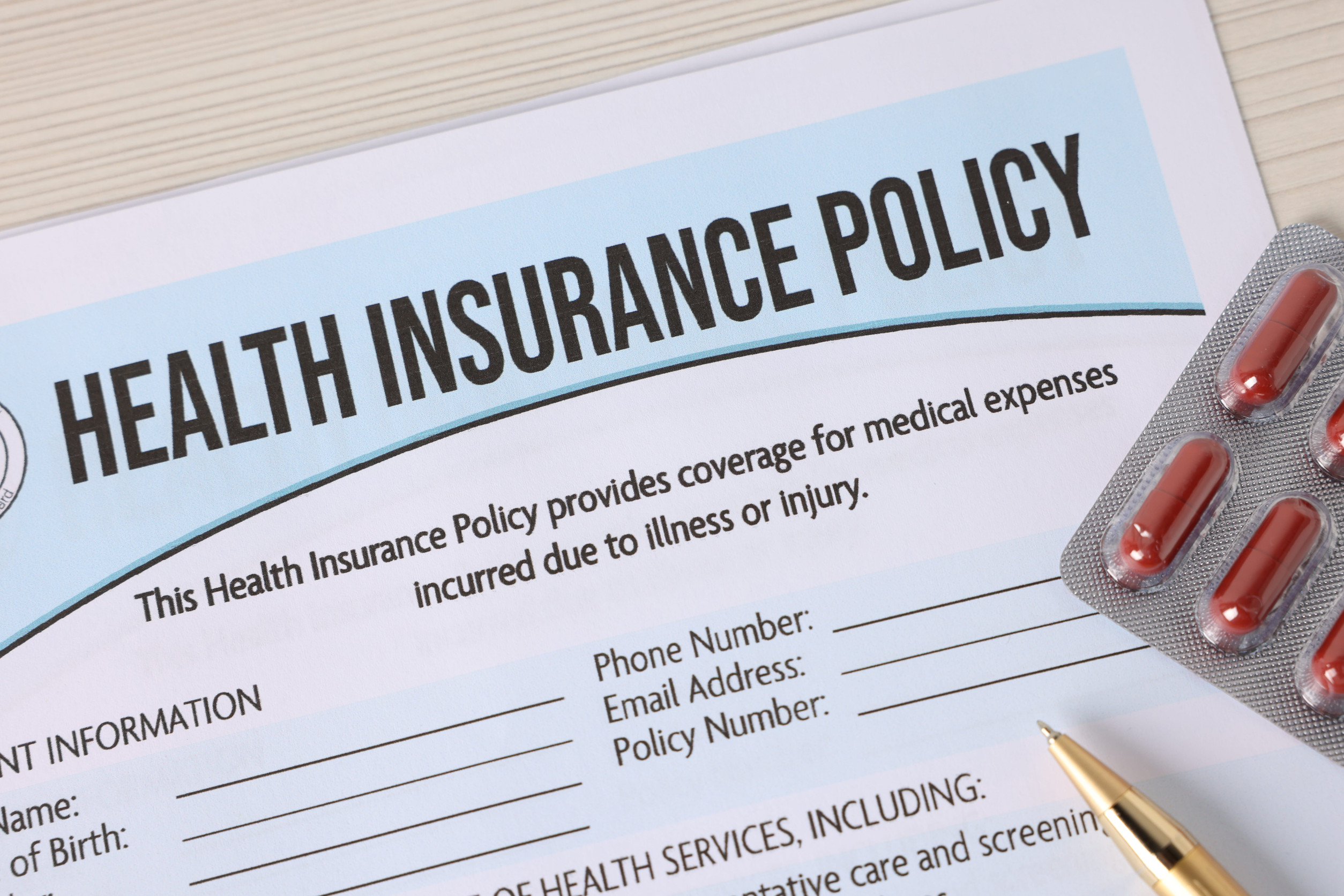 Health insurance policy, pen and pills