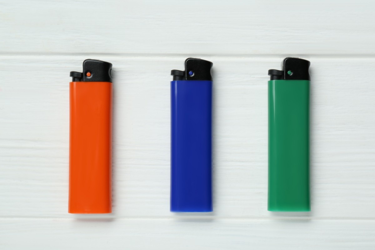 Pocket Lighters On White Wooden Background